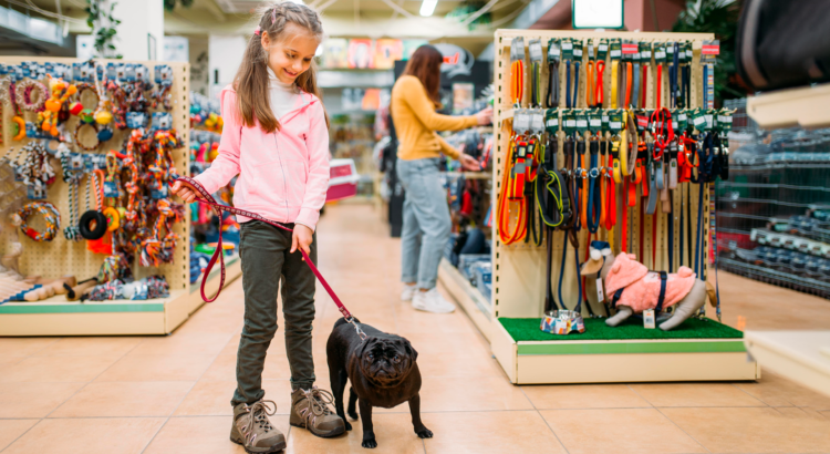 دختر بچه در فروشگاه لوازم حیوانات خانگی با سگ